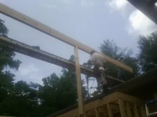 Carpenter setting a ridge beam over a new addition frame — Ice Dam Removal by Roofing Brothers in Indiana