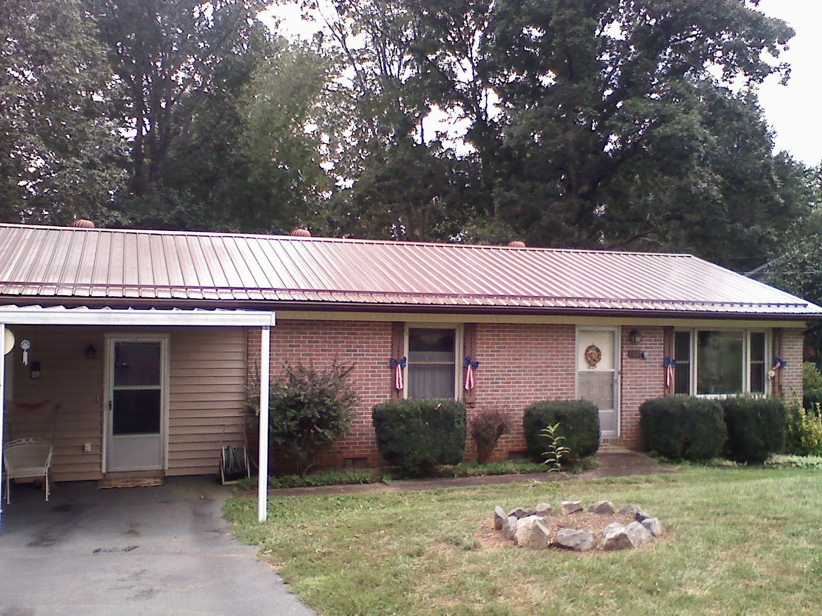 Bronze metal roof and carport on a brick ranch home — Roof Repair work by our crew in Indiana